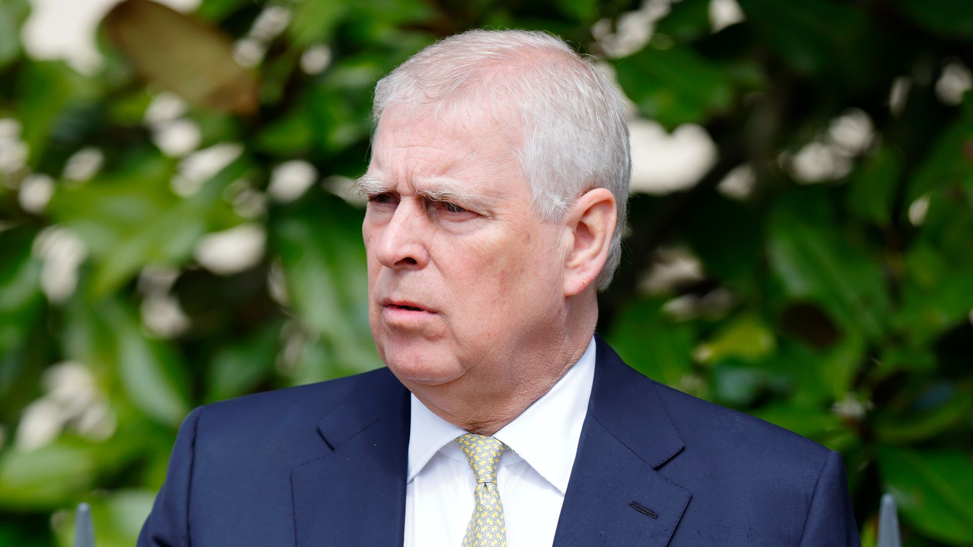Prince Andrew frowning in blue suit