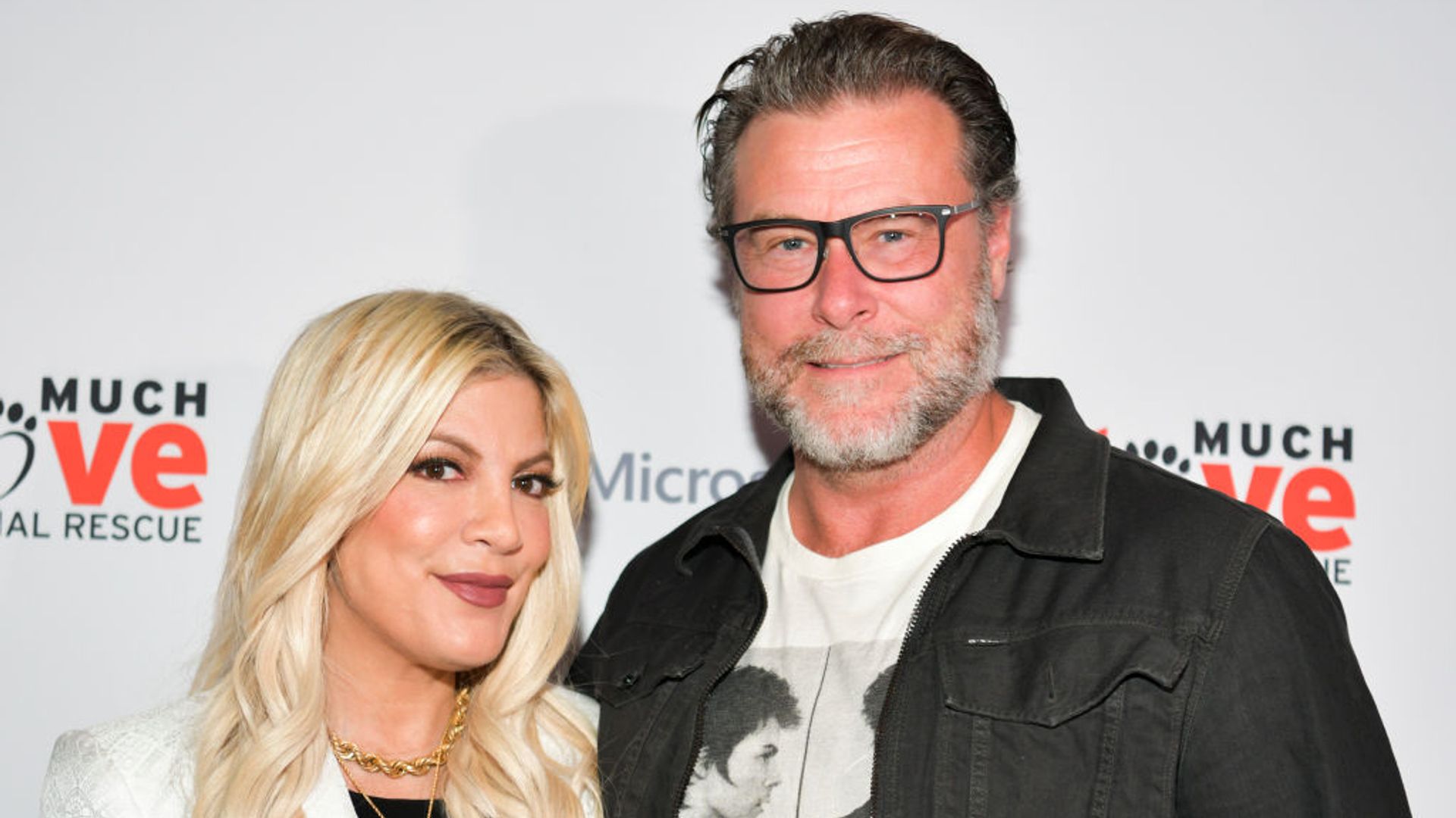 Dean McDermott and Tori Spelling pose together at a red carpet event. 