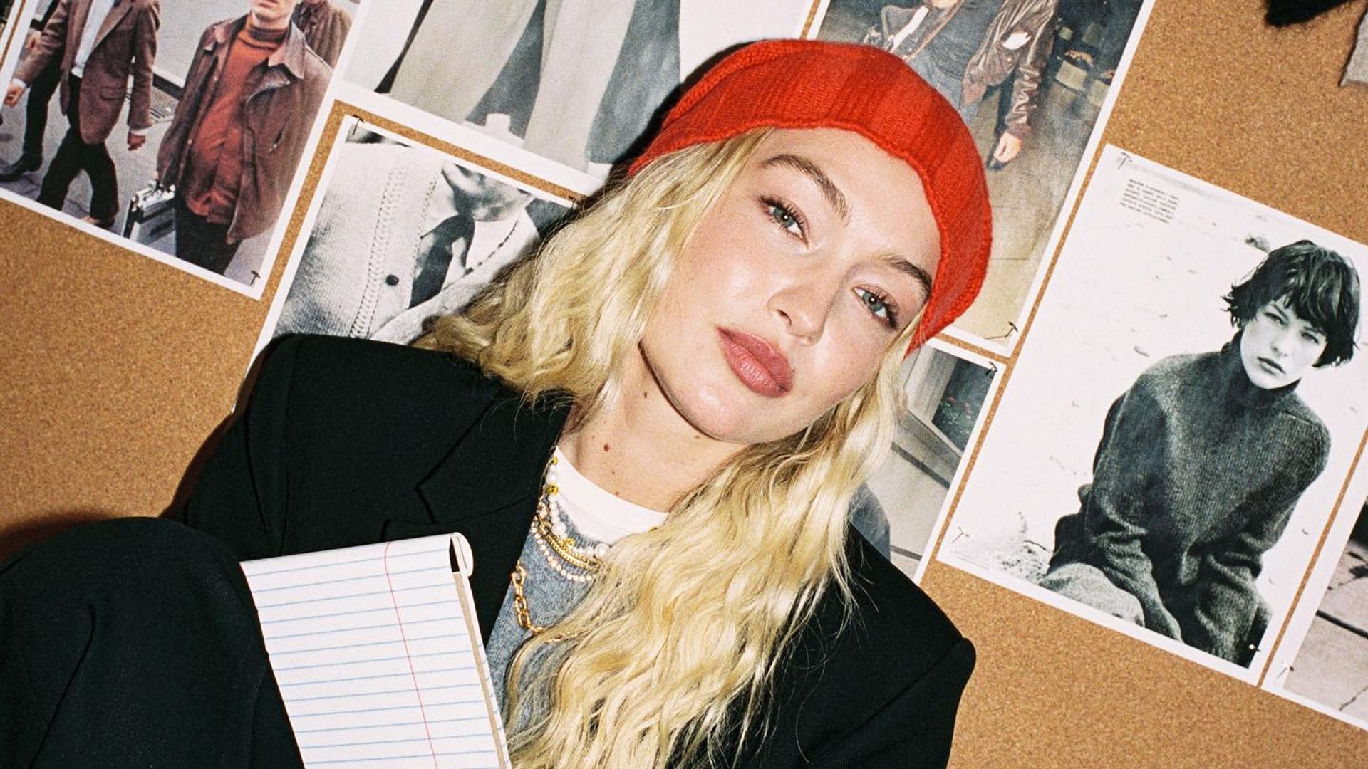 Gigi Hadid poses in a red beanie 