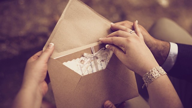 couple holding wedding invitation