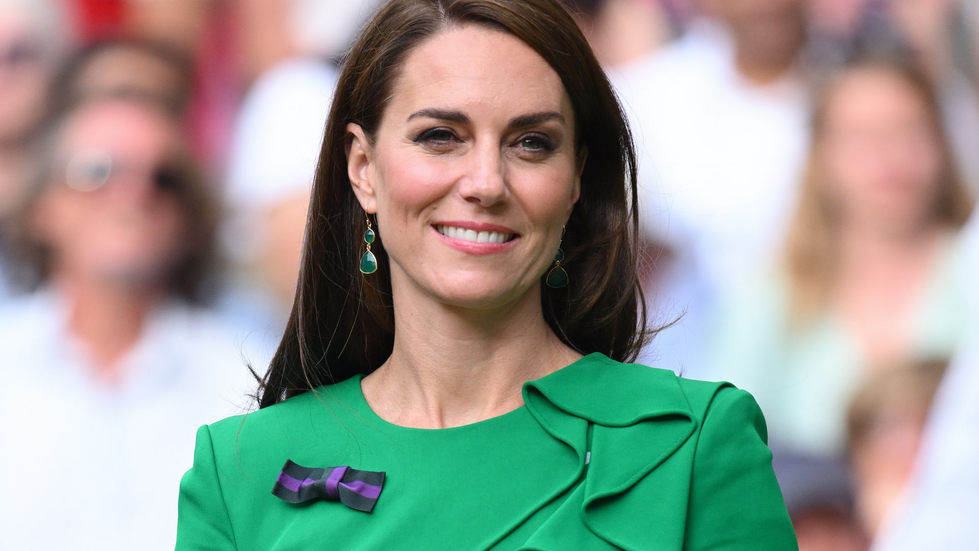 Princess of Wales smiling in green dress with bow pin