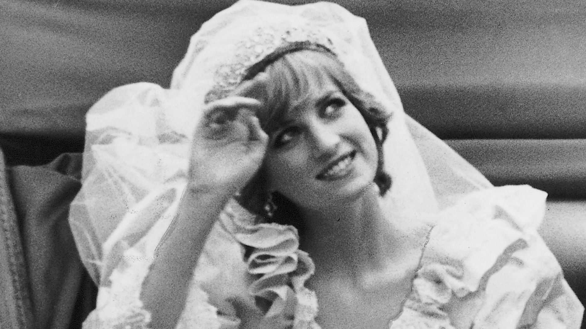 Princess Diana touching her tiara in her wedding carriage