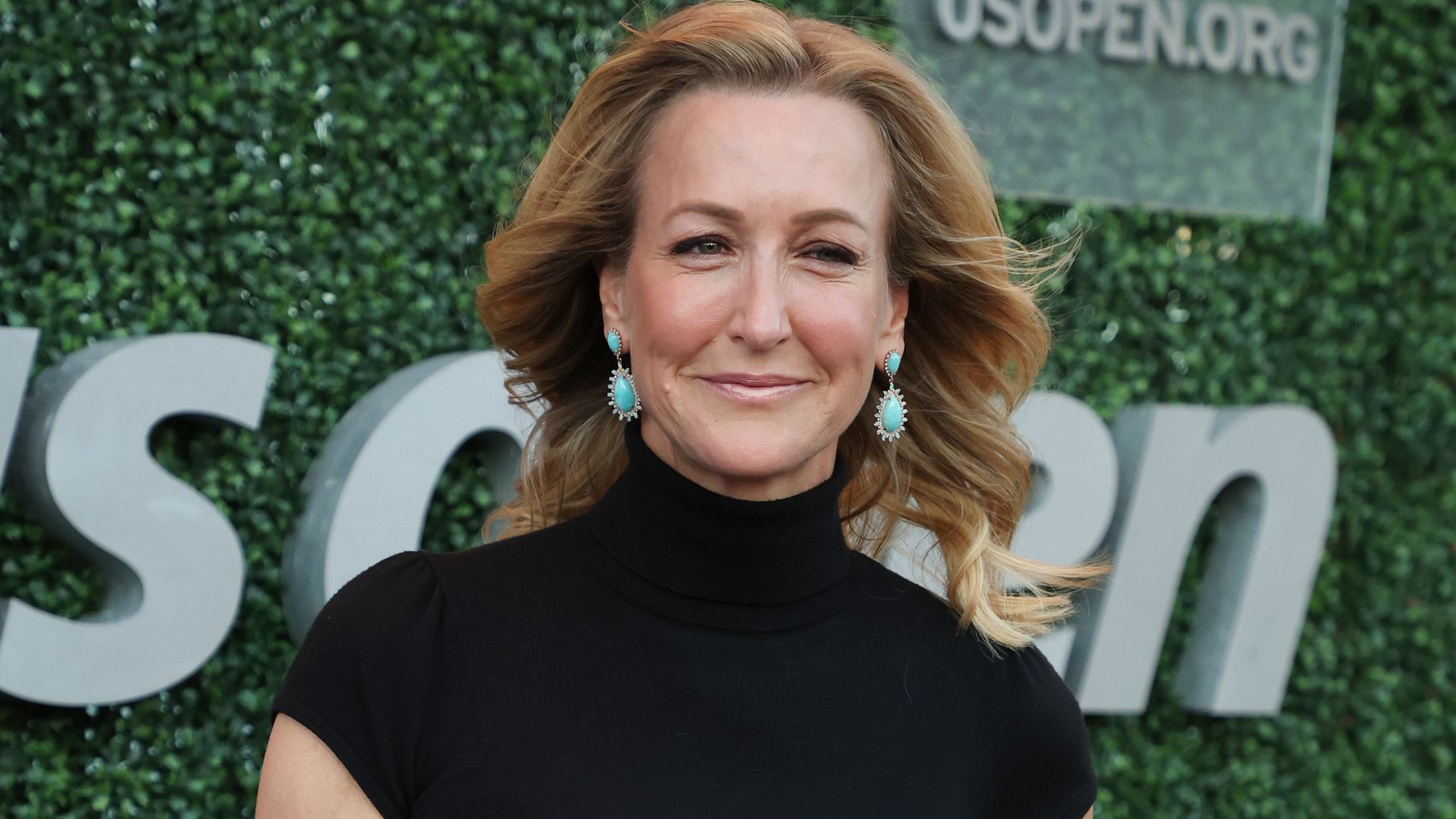 Lara Spencer in black top and lime trousers