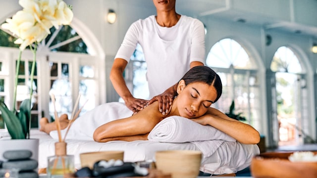 Shot of an attractive young woman lying on a bed and enjoying a massage at the spa