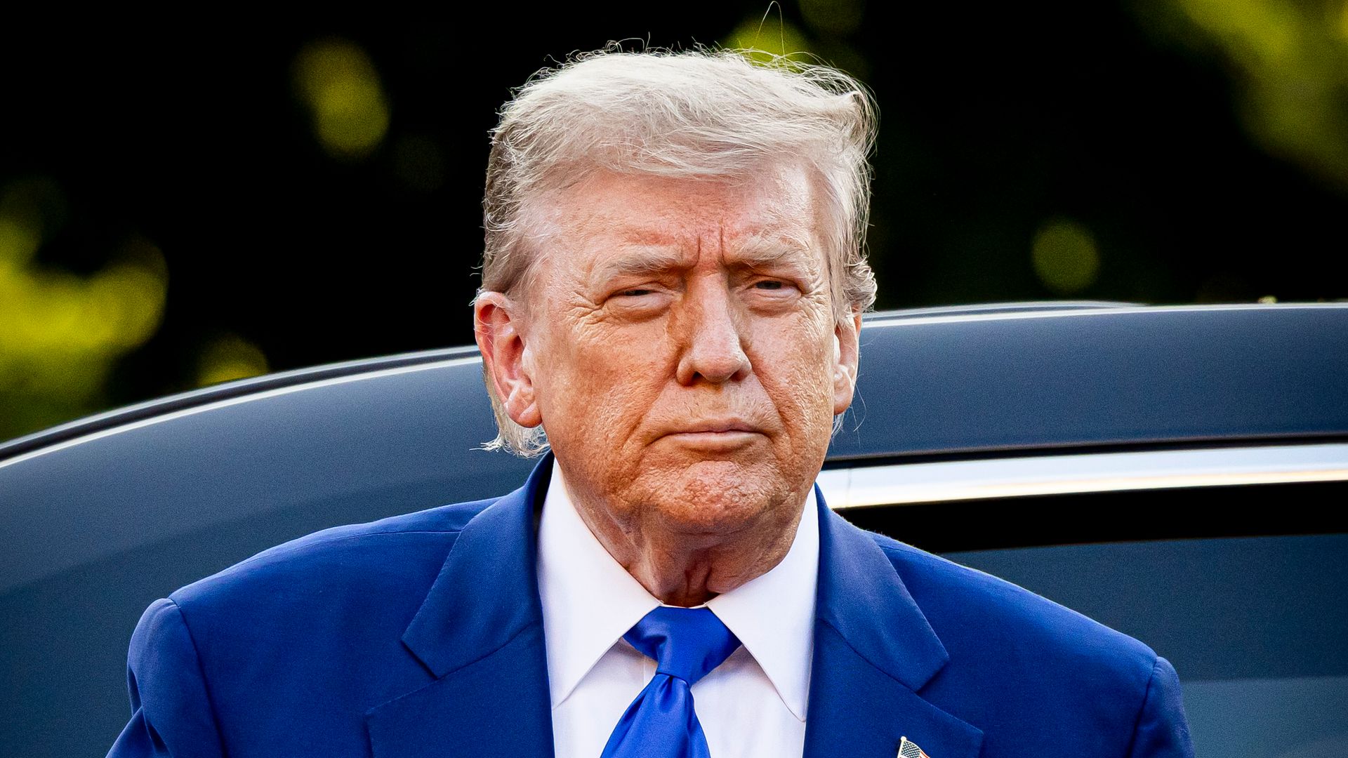 Donald Trump exiting car in blue suit