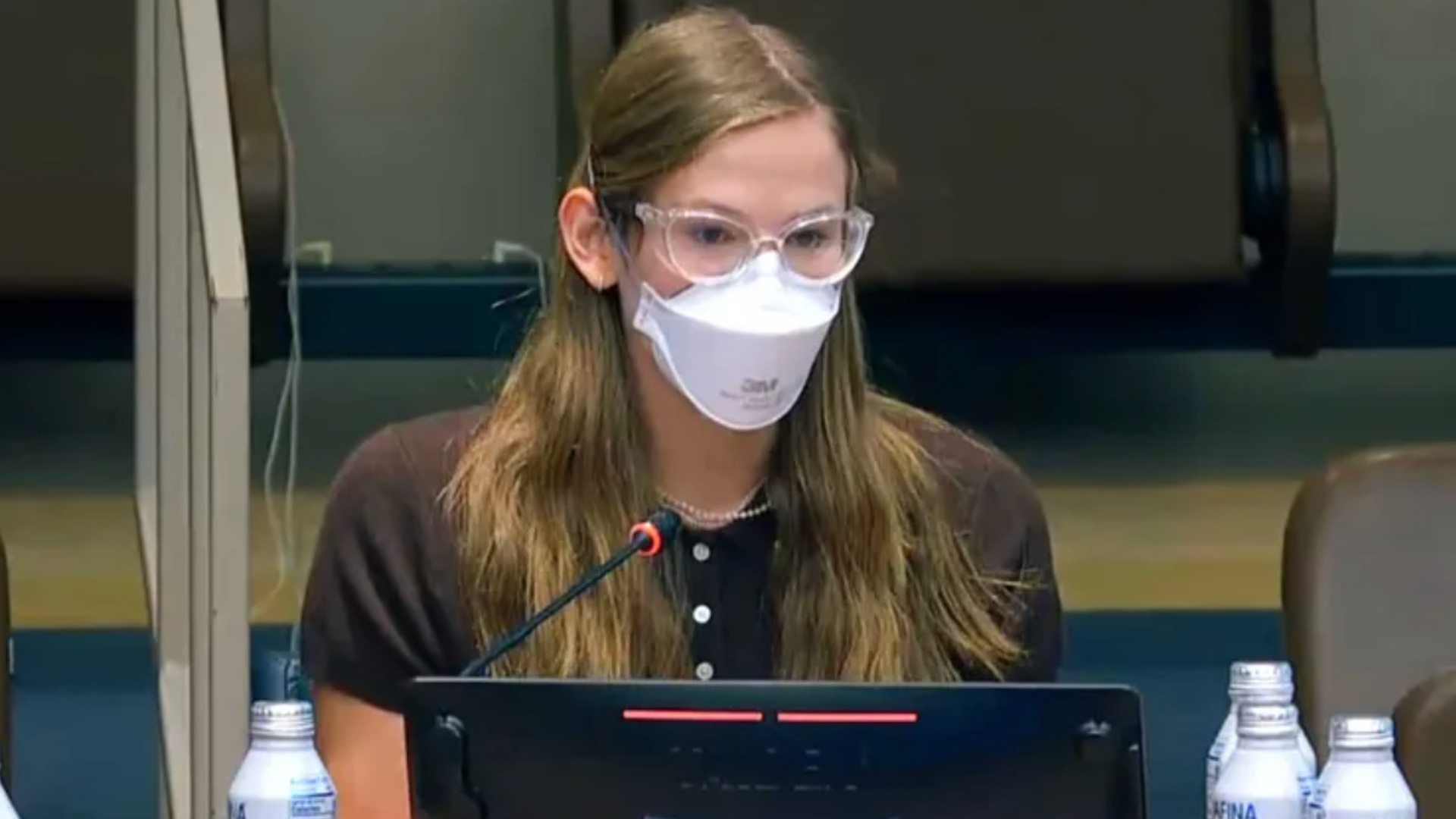 Violet Affleck in brown top wearing mask and glasses