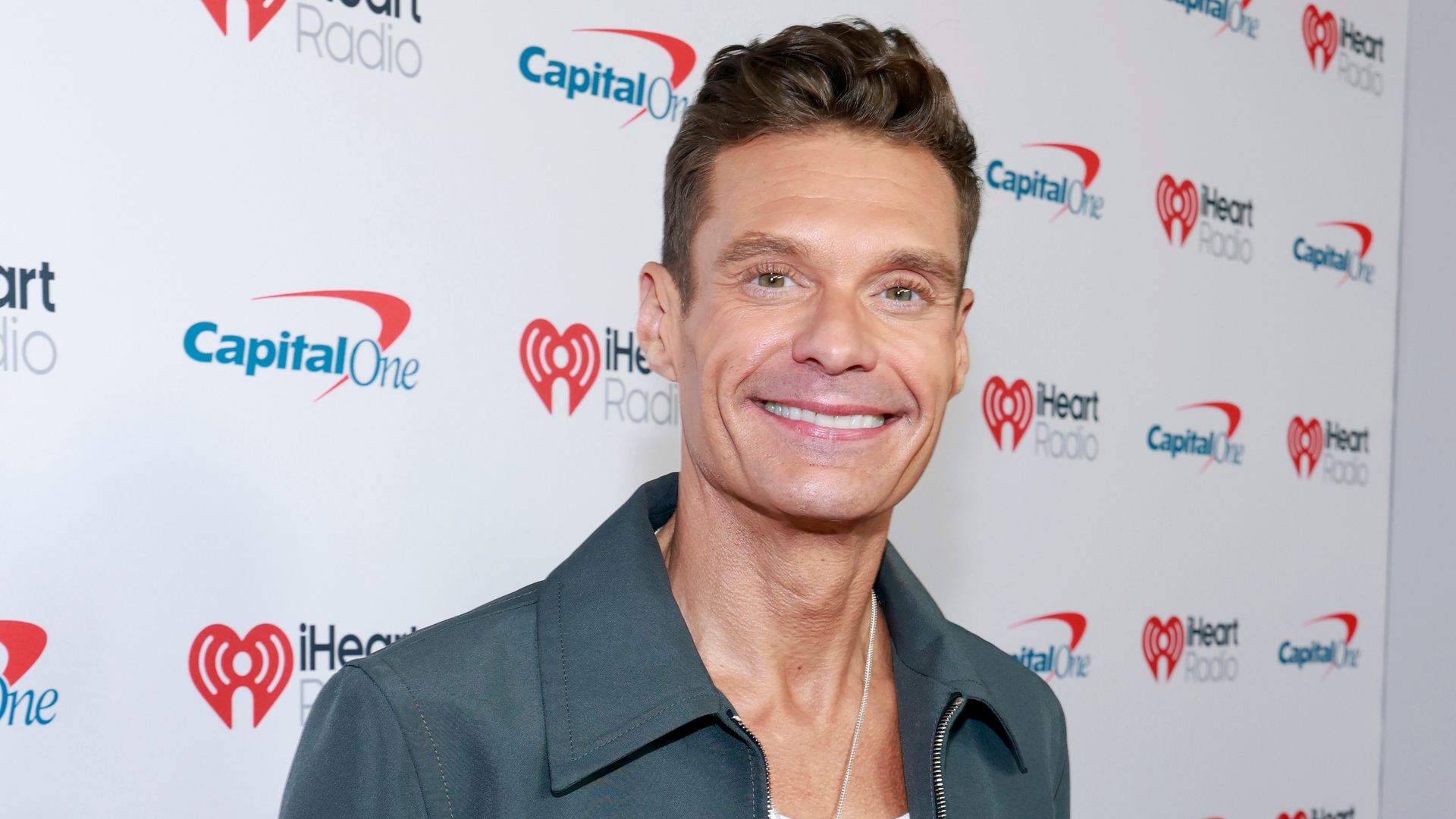 Ryan Seacrest in gray jacket and white t-shirt