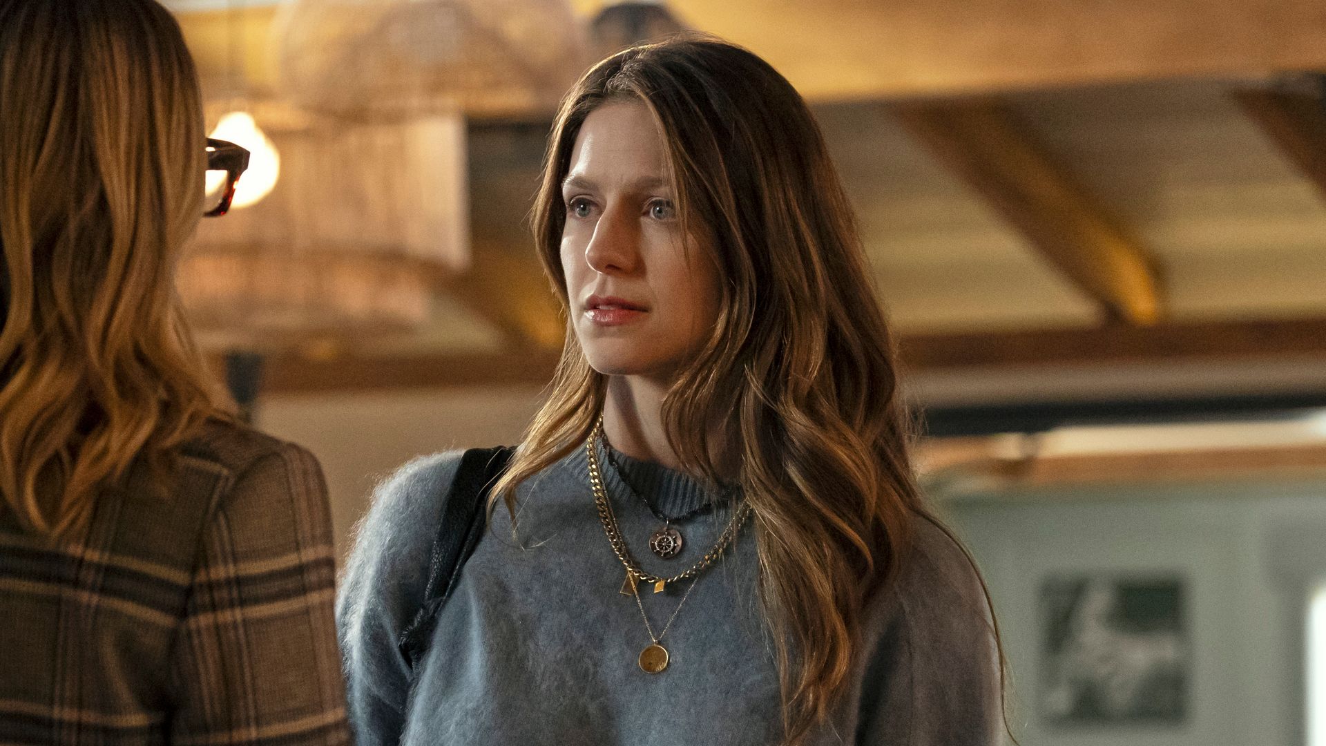 woman in grey jumper looking at other woman in restaurant