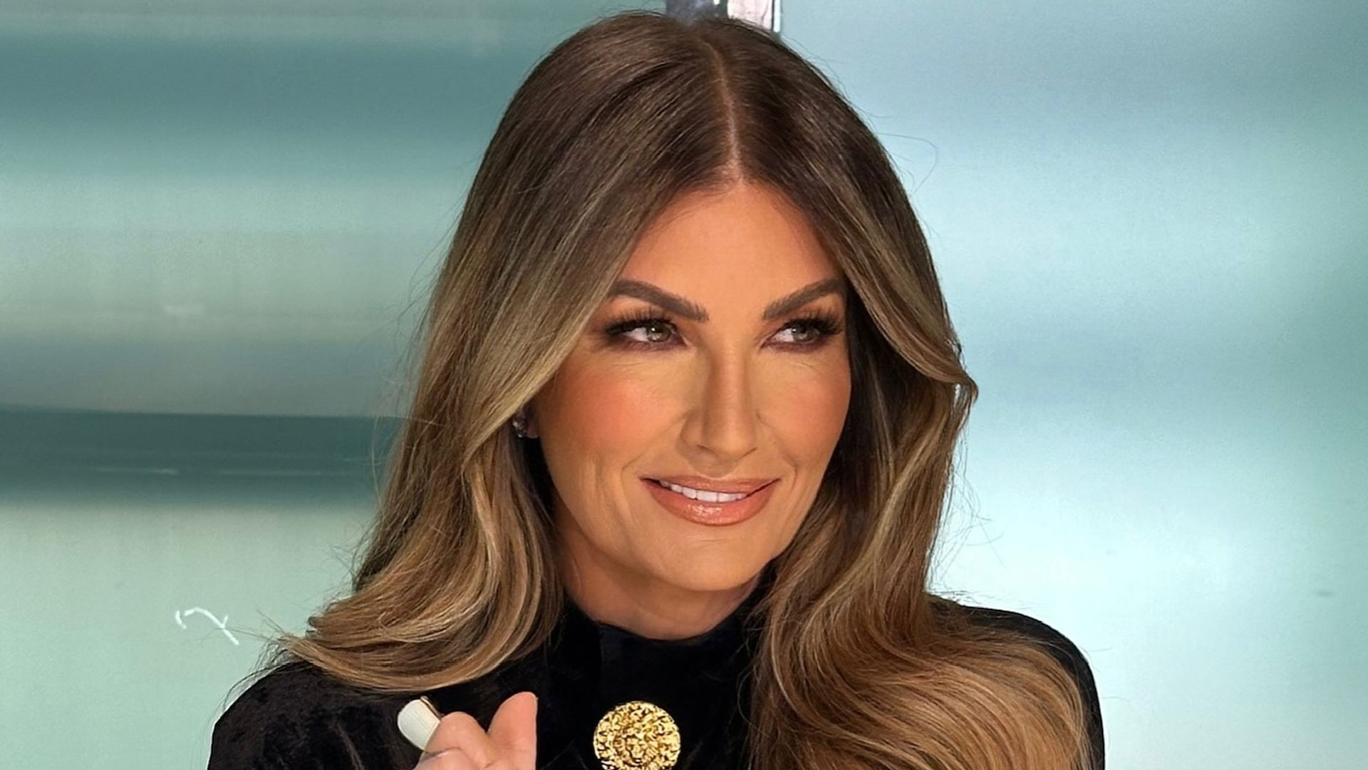 Karren Brady smiling with her hair piled to one side 