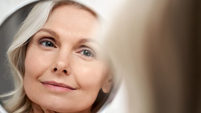 Stylish 40s woman looking in mirror