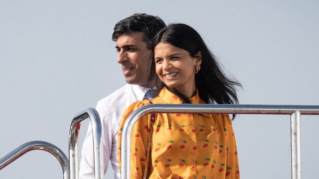 Britain's Prime Minister Rishi Sunak (L) and his wife Akshata Murty board a plane following the G7 Leaders' Summit in Hiroshima on May 21, 2023.