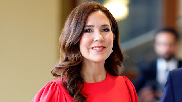 Queen Mary smiles in red dress