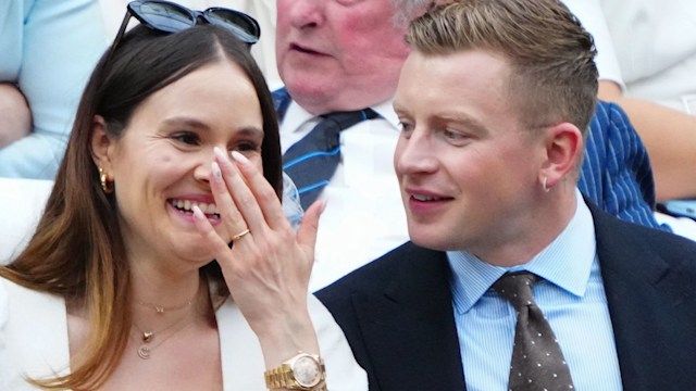 Holly Ramsay laughing in a white dress next to Adam Peaty