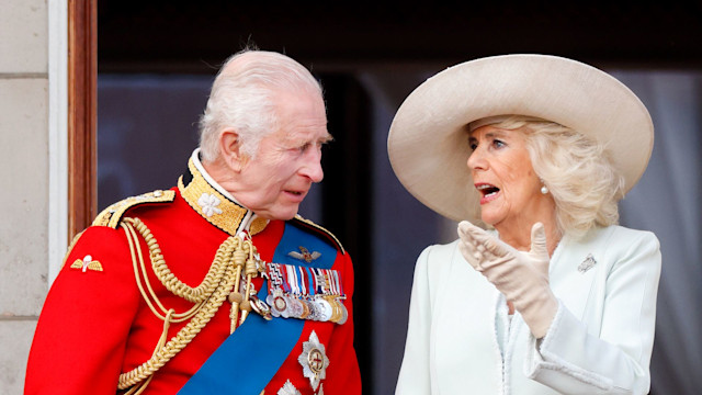 King Charles III, wearing his Irish Guards uniform, and Queen Camilla watch an RAF flypast from the balcony of Buckingham Palace after attending Trooping the Colour