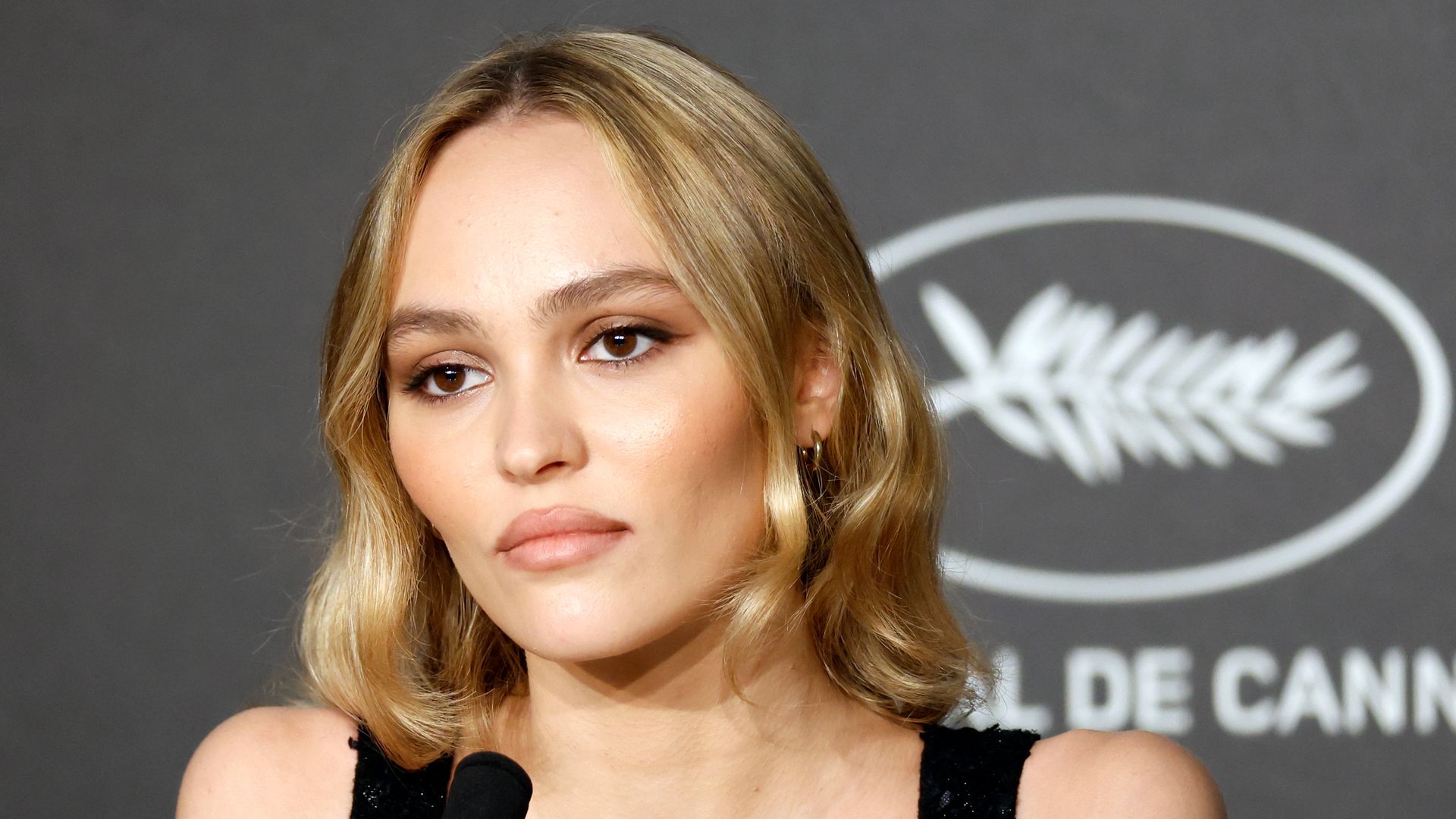 Lily-Rose Depp speaks into mic at Cannes Festival for The Idol premiere