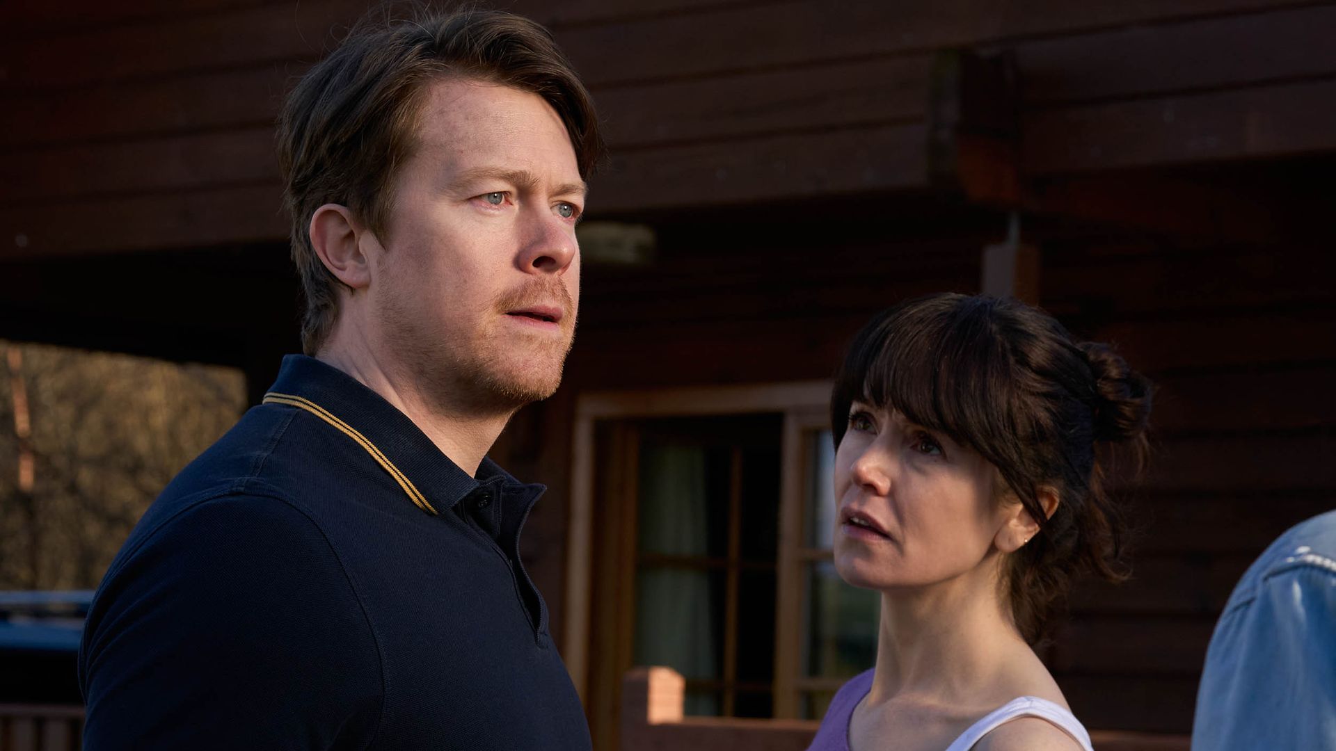 man and woman outside cabin