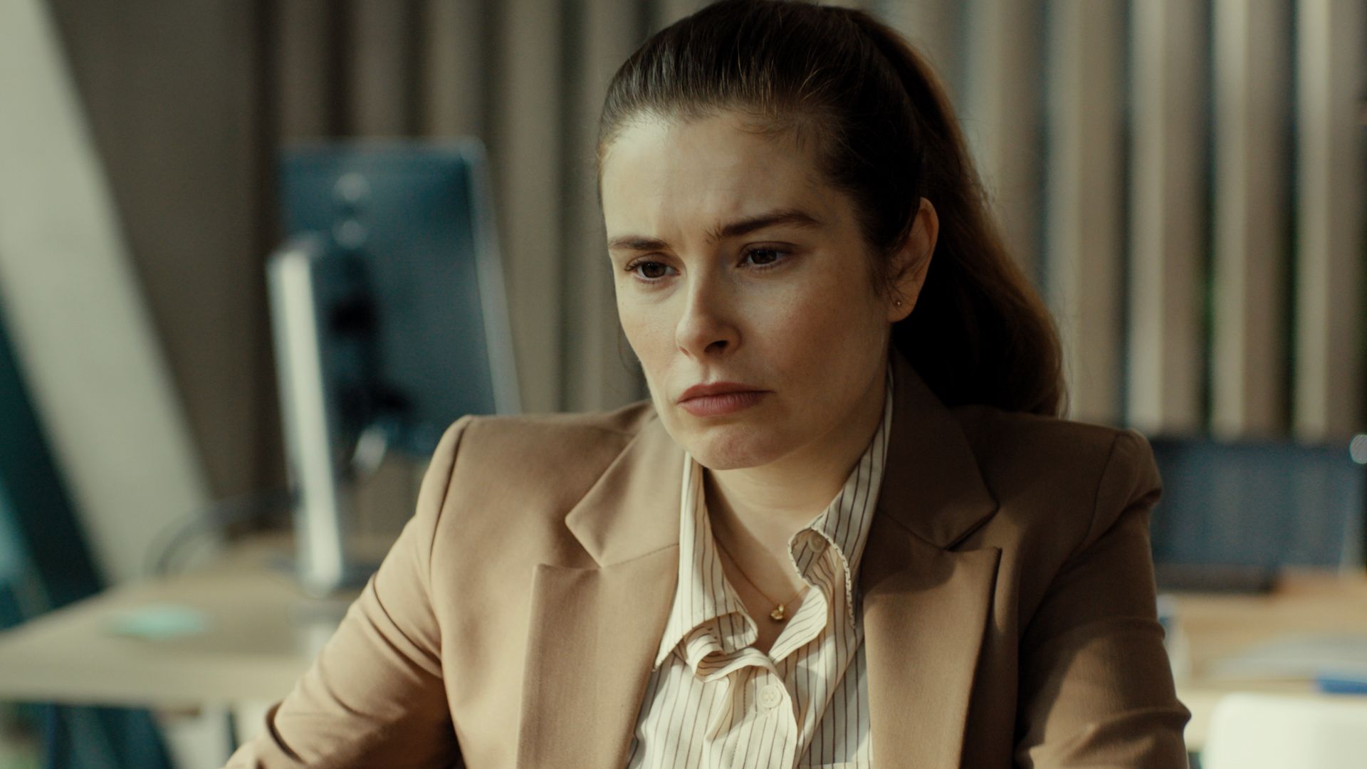close-up woman in beige suit in office