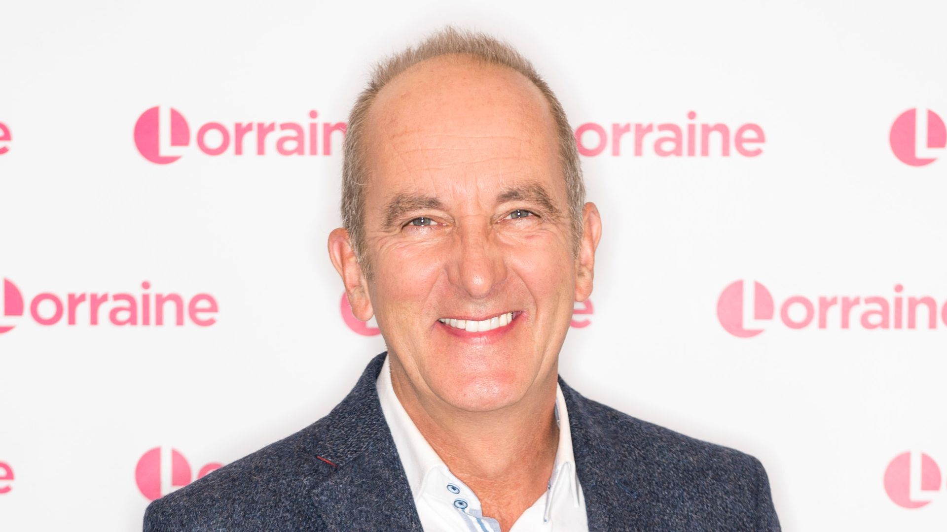 Kevin McCloud smiling while wearing a suit
