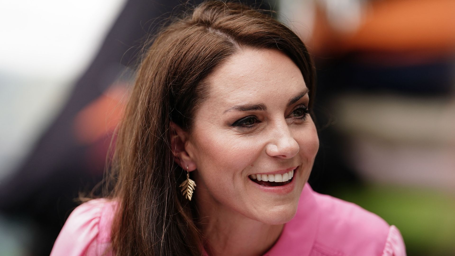 Kate Middleton wearing a pink dress and smiling at Chelsea Flower Show