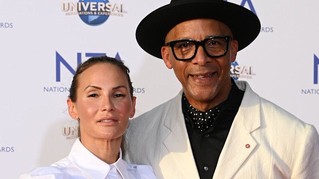 Jay Blades in a cream jacket and black hat with wife Lisa in a white shirt