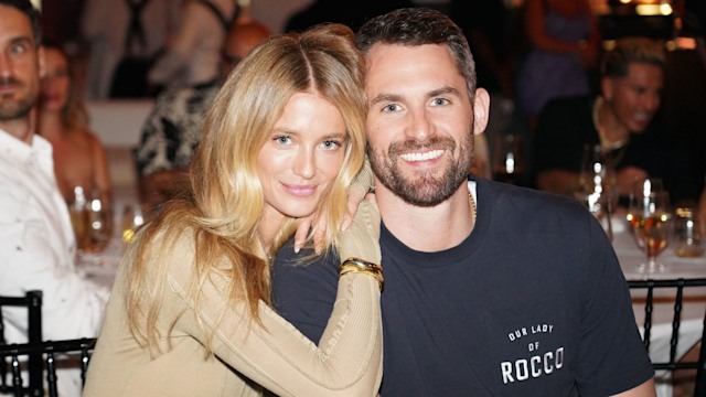 Kevin Love and Kate Bock sat at a fancy event leaning on each other and smiling lovingly