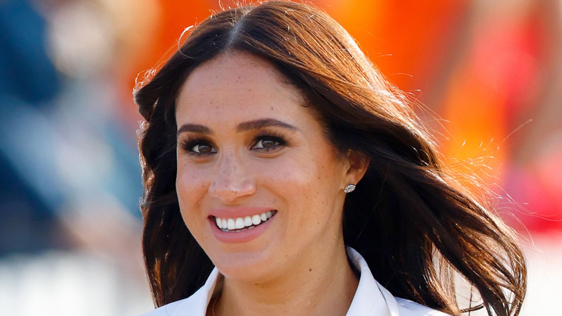 Meghan Markle smiling in white suit 