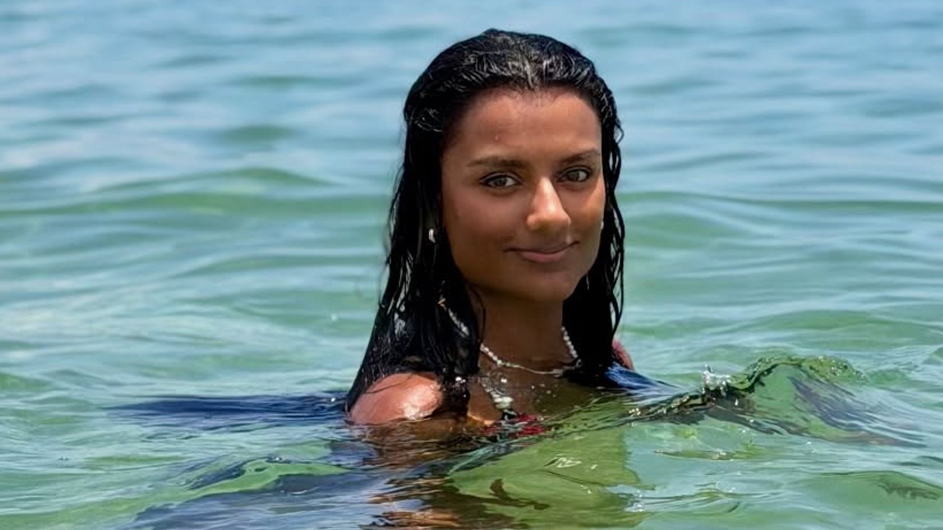 Simone Ashley poses in the ocean for a picture