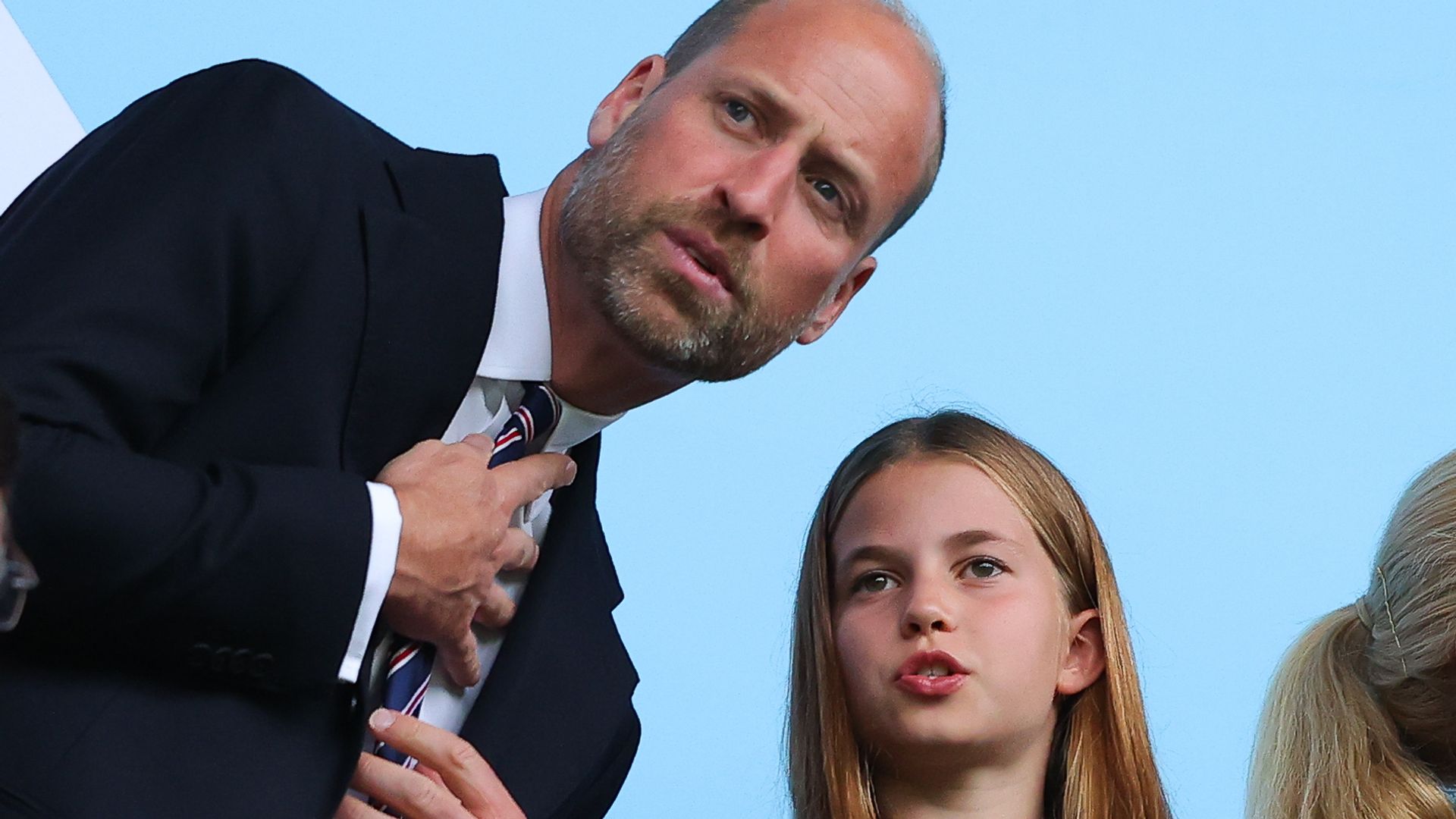 Princess Charlotte in a polka dot dress talking to Prince William as he leaned down