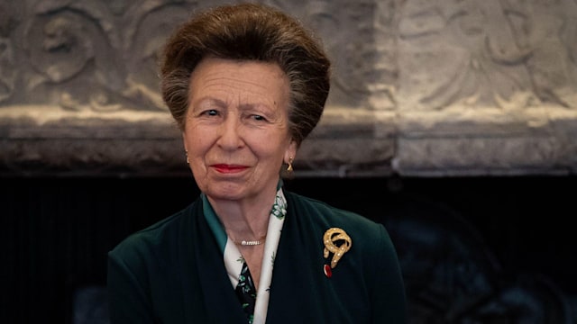 Princess Anne wearing green dress and gold ribbon brooch