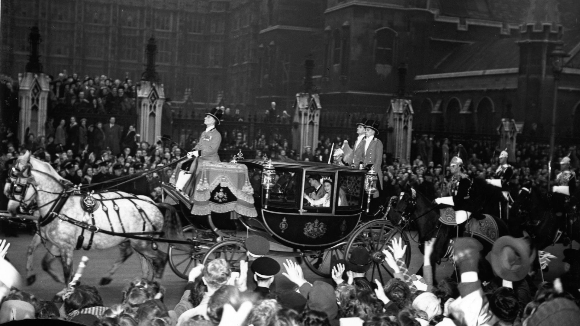 Prince Philip and the Queen waving from their wedding carriage