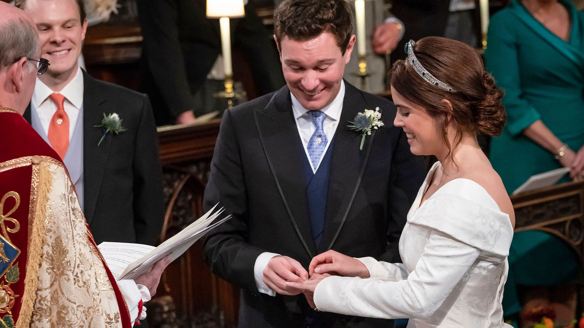 Jack Brooksbank places a wedding band on the finger of his bride, Britain's Princess Eugenie of York during their wedding ceremony 