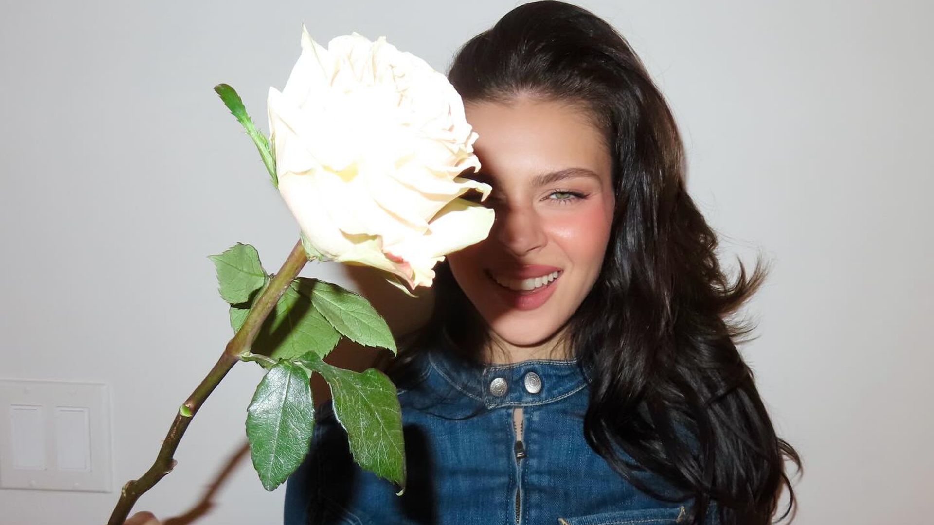 Nicola poses with a rose that her husband Brooklyn Beckham bought her