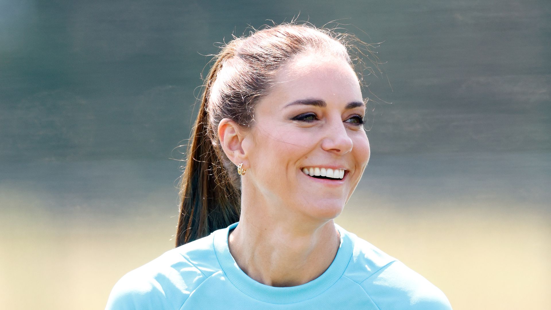 Kate Middleton smiling in blue rugby top