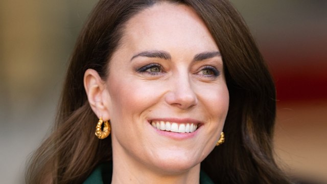 Kate Middleton, Princess of Wales wearing gold earrings and a green coat during the tour of Kirkgate Marke.