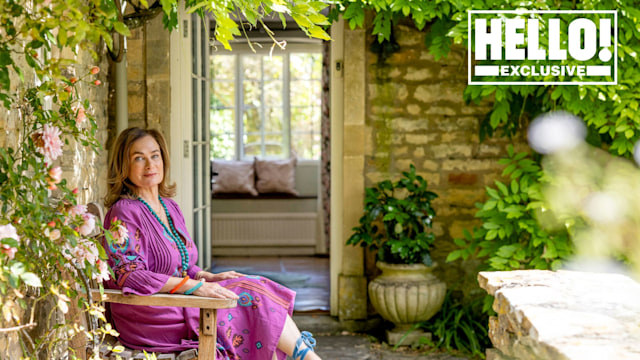 Penelope Chilvers in purple dress and blue shoes sitting outside at Cotswolds home