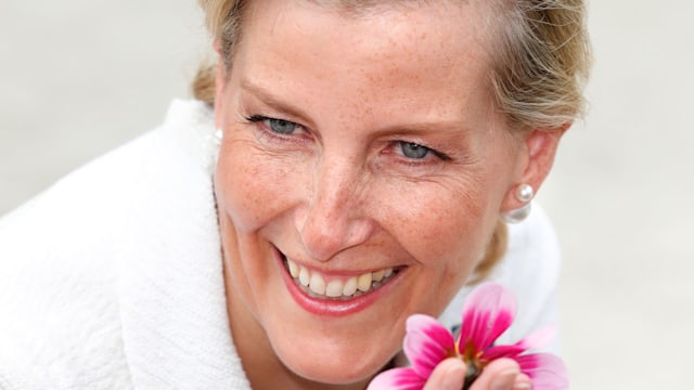 Sophie smiling sniffing flower