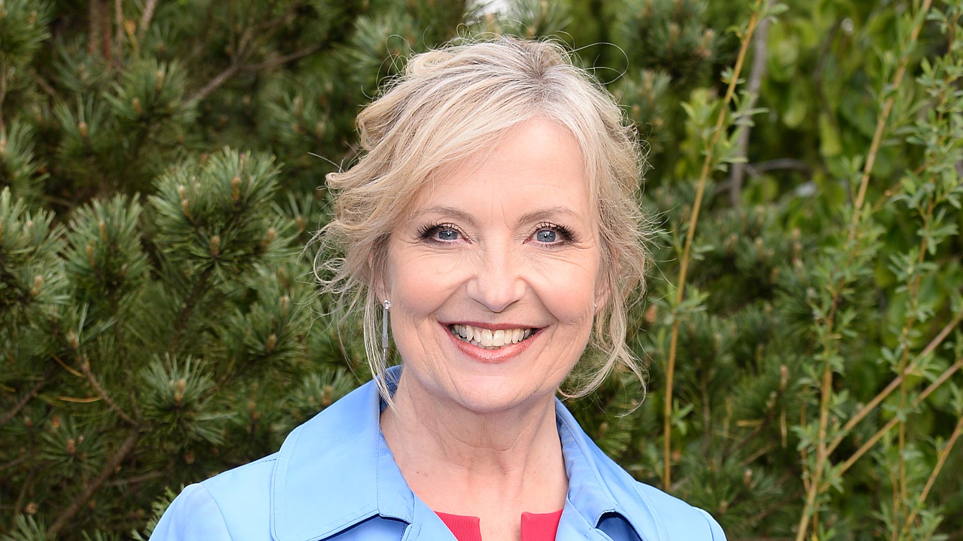 Carol Kirkwood in a baby blue coat and red dress