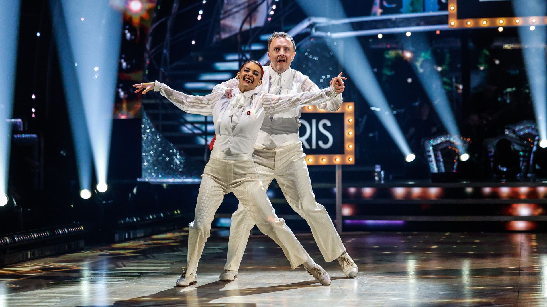 Chris McCausland and Dianne Buswell dancing in white suits