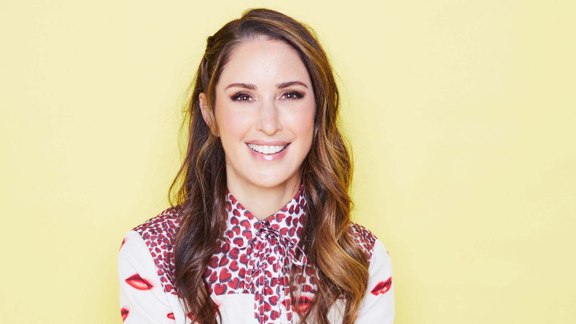 Woman in a printed dress against a yellow background