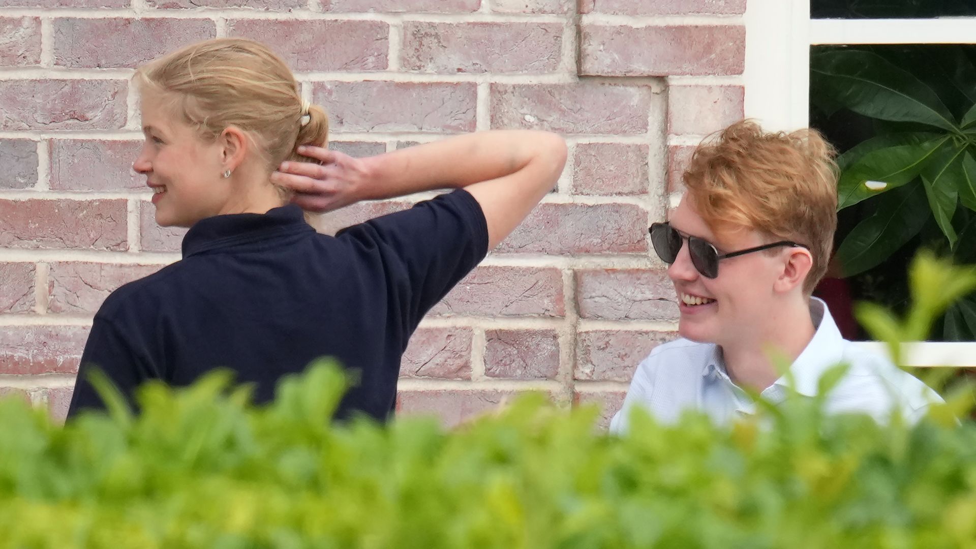 Lady Louise Windsor with her elbow by her head as she talks with Felix da Silva-Clamp