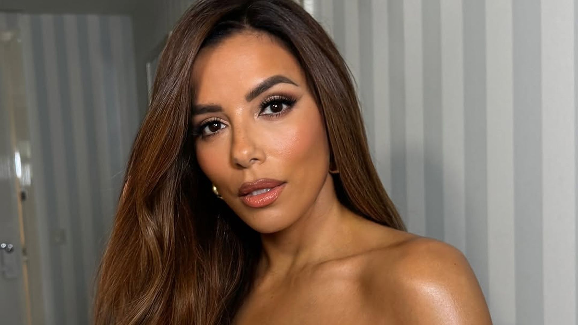 eva longoria in a white satin jumpsuit and bronzed hair 