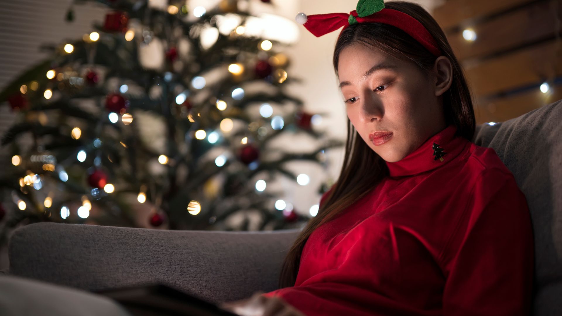 An Asian woman who spent Christmas or New year alone away while using a digital tablet at her apartment.