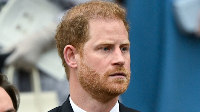 Prince Harry looking serious in a black suit