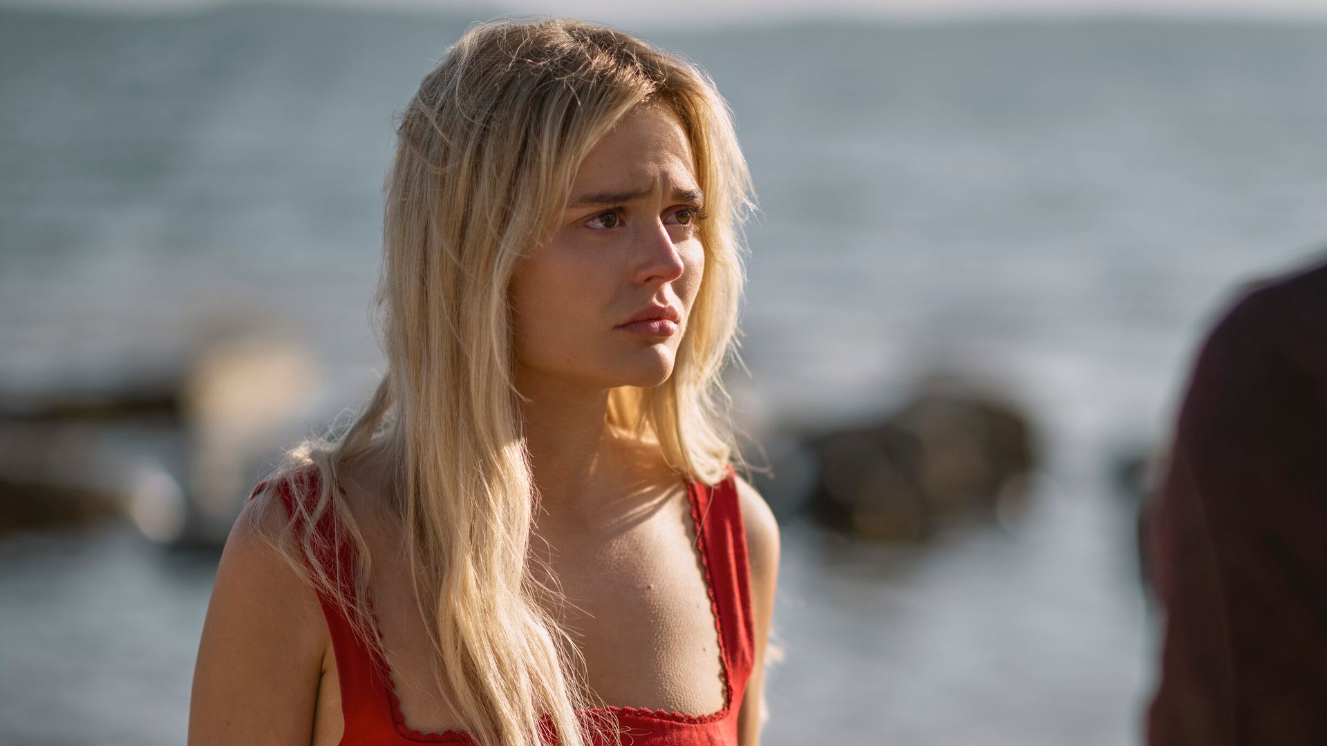 young woman in red top standing on beach