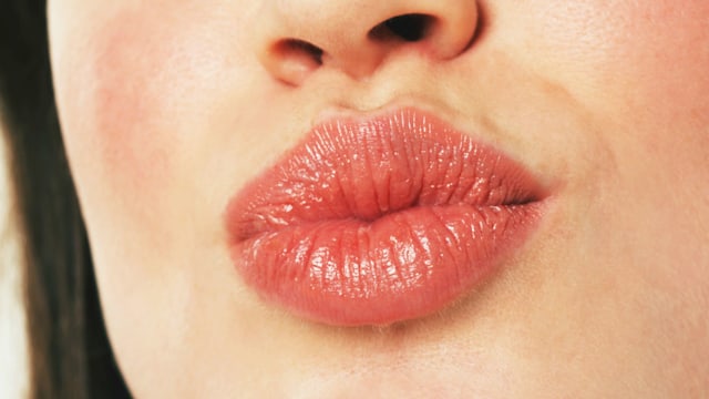 woman puckering lips, close-up