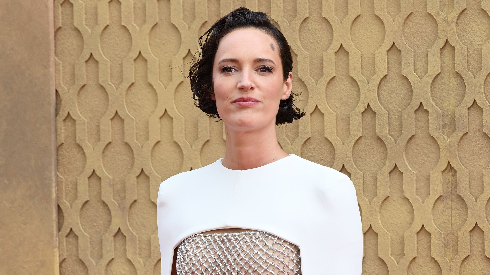 Phoebe Waller-Bridge in a shiny lattice dress with a white cape overlay at the Indiana Jones premiere