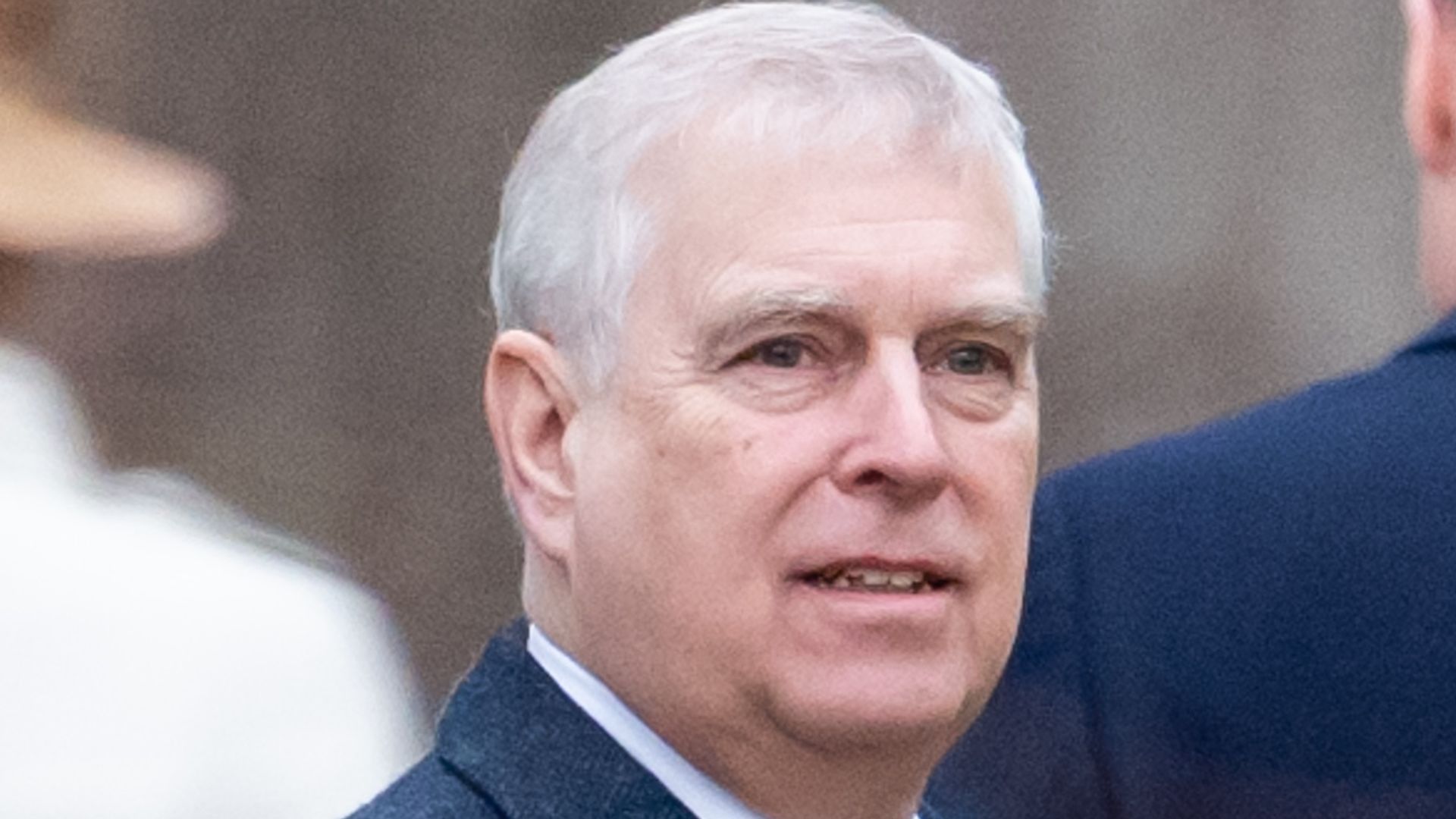 Andrew looking to right in navy smart coat