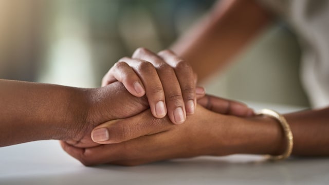 Friends holding hands in support