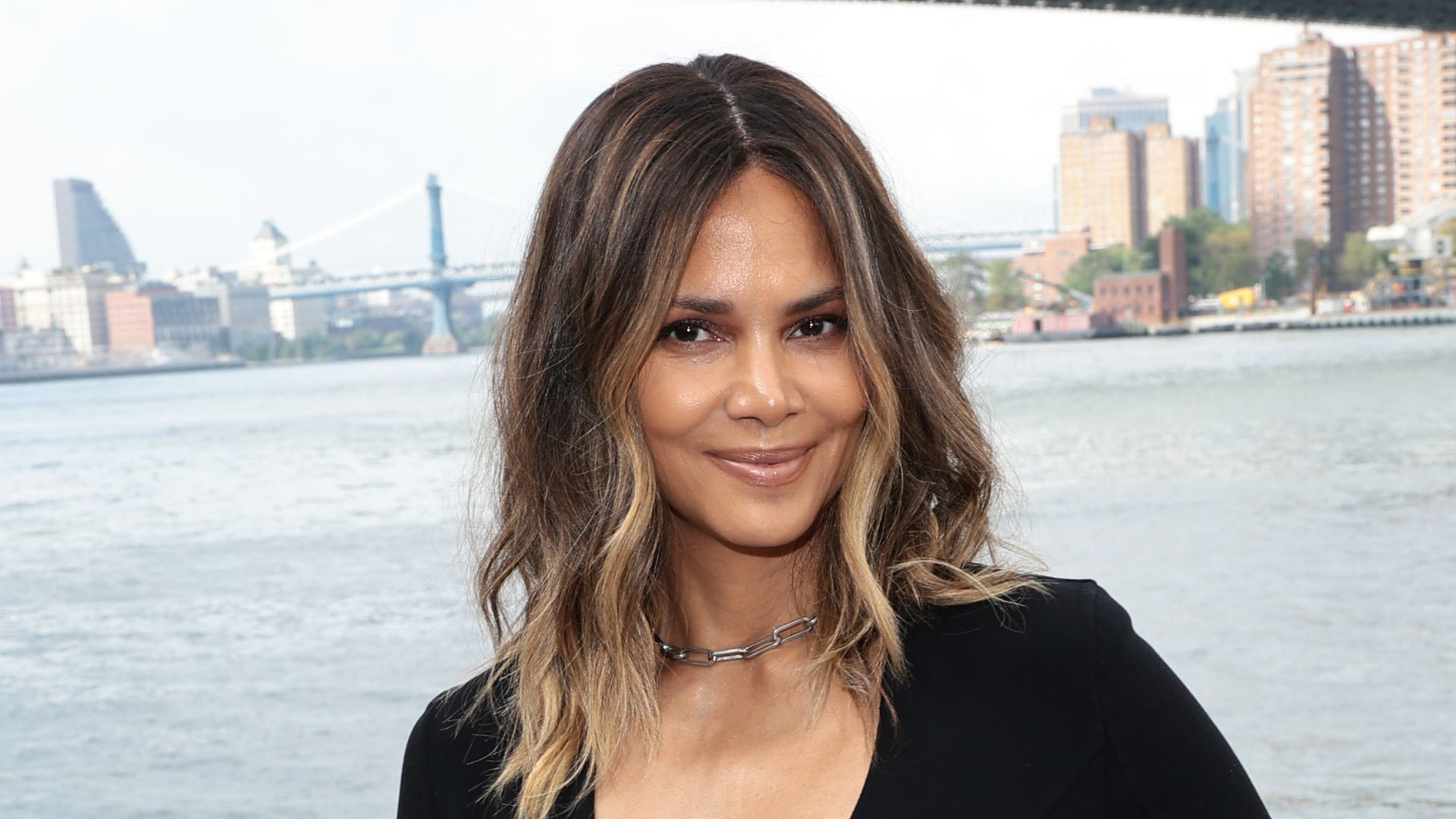 Halle Berry puts toned beach body on display in plunging black swimsuit