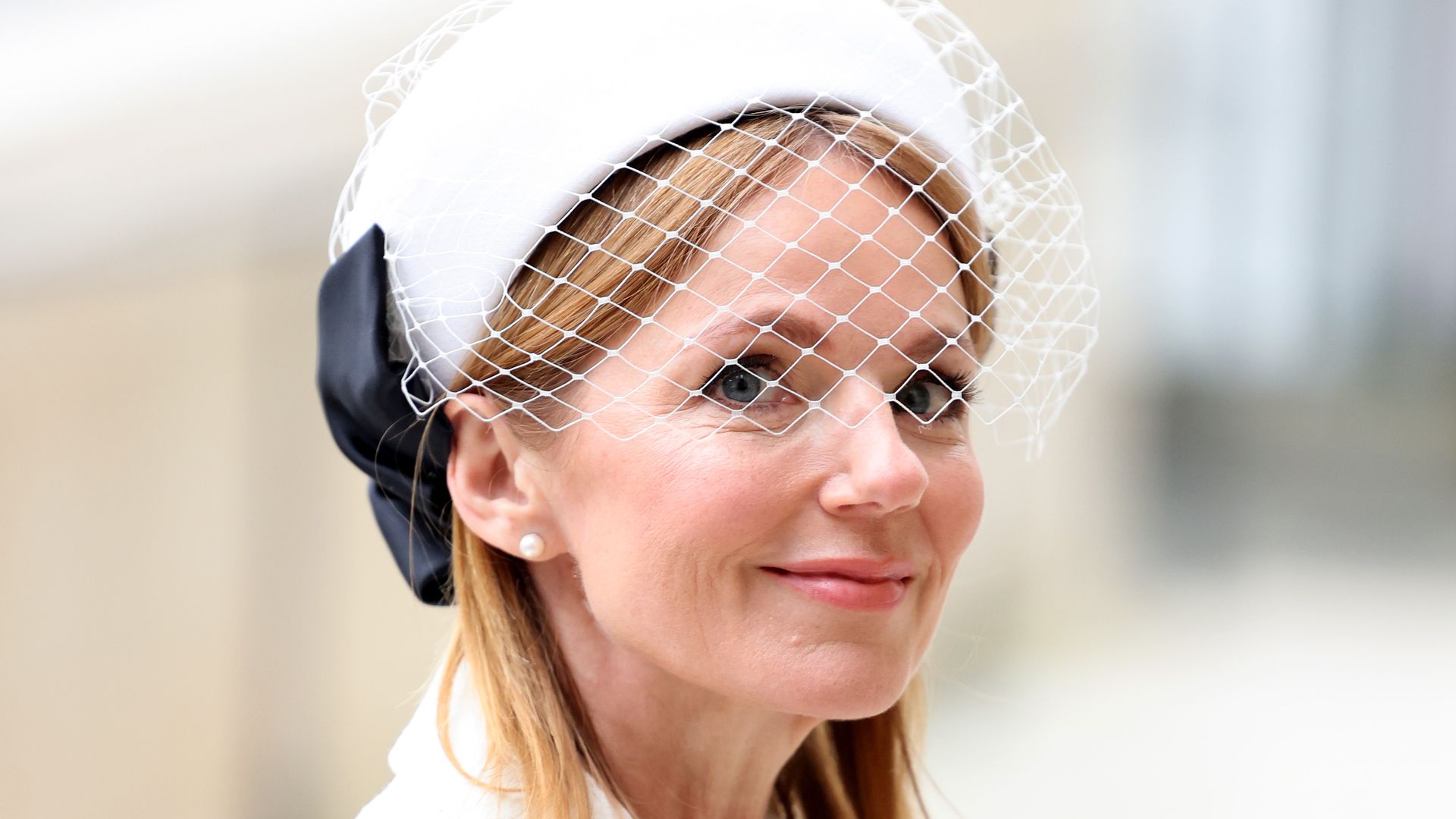 Geri Halliwell-Horner smiling in a white veiled hat